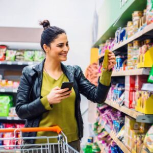 woman smiling holding food product in store